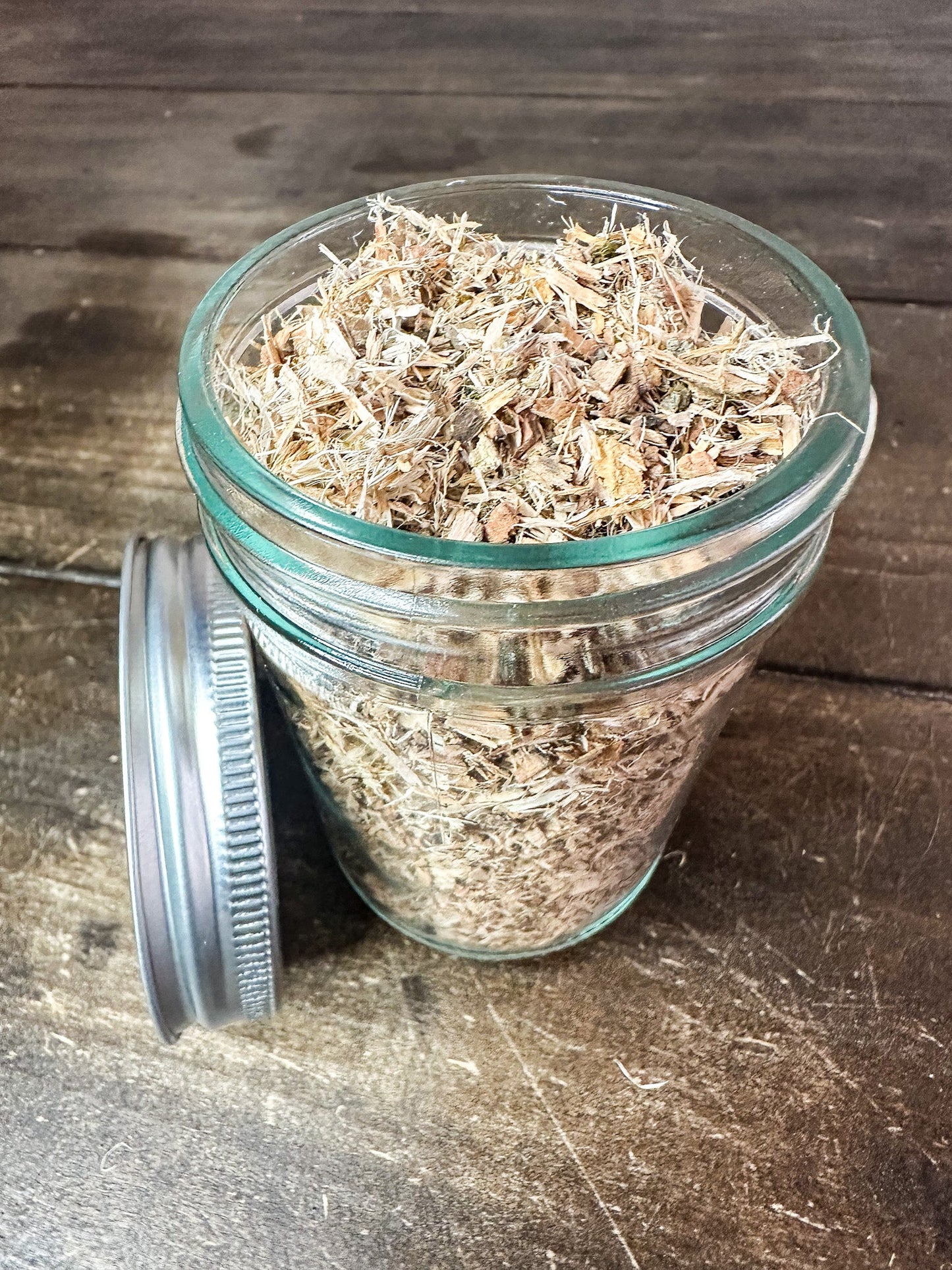 Small jar of dried white willow bark herbs in a herbalroseapothecary herb jar, showcasing herbal remedy packaging.