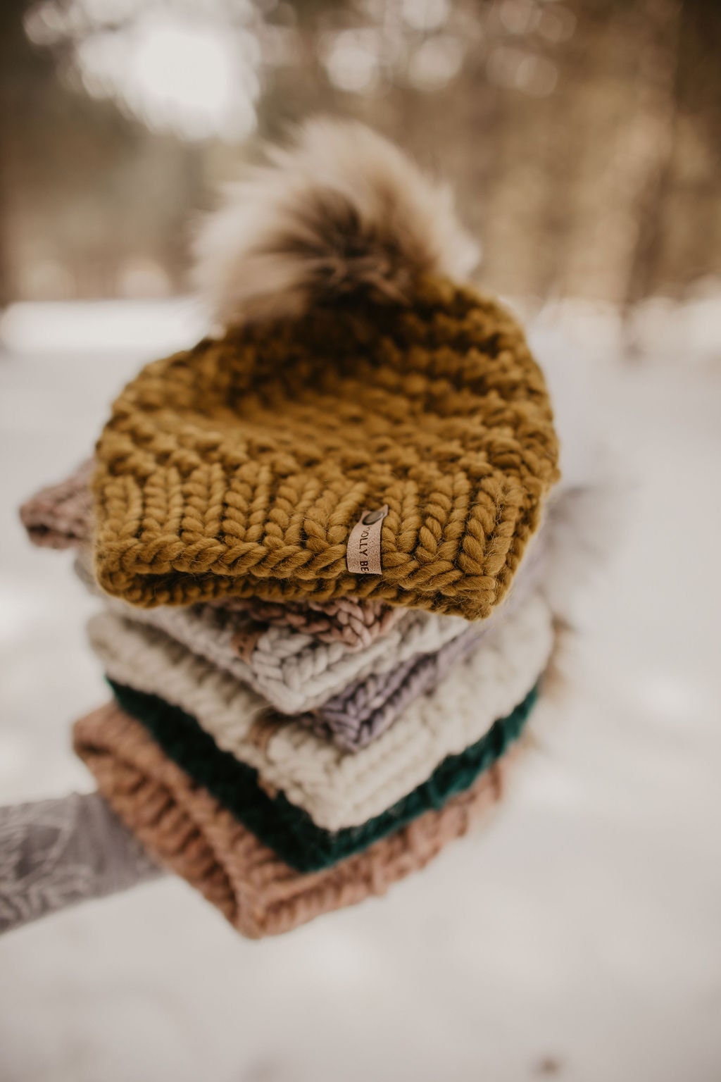 Forest green Peruvian wool knit hat with faux fur pom pom by Woolly Bear Knits, showcasing cozy, warm winter headwear.