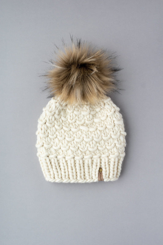 Ivory Peruvian wool knit hat with faux fur pom-pom by Woolly Bear Knits, showcasing warm, textured wool and fluffy pom-pom detail.