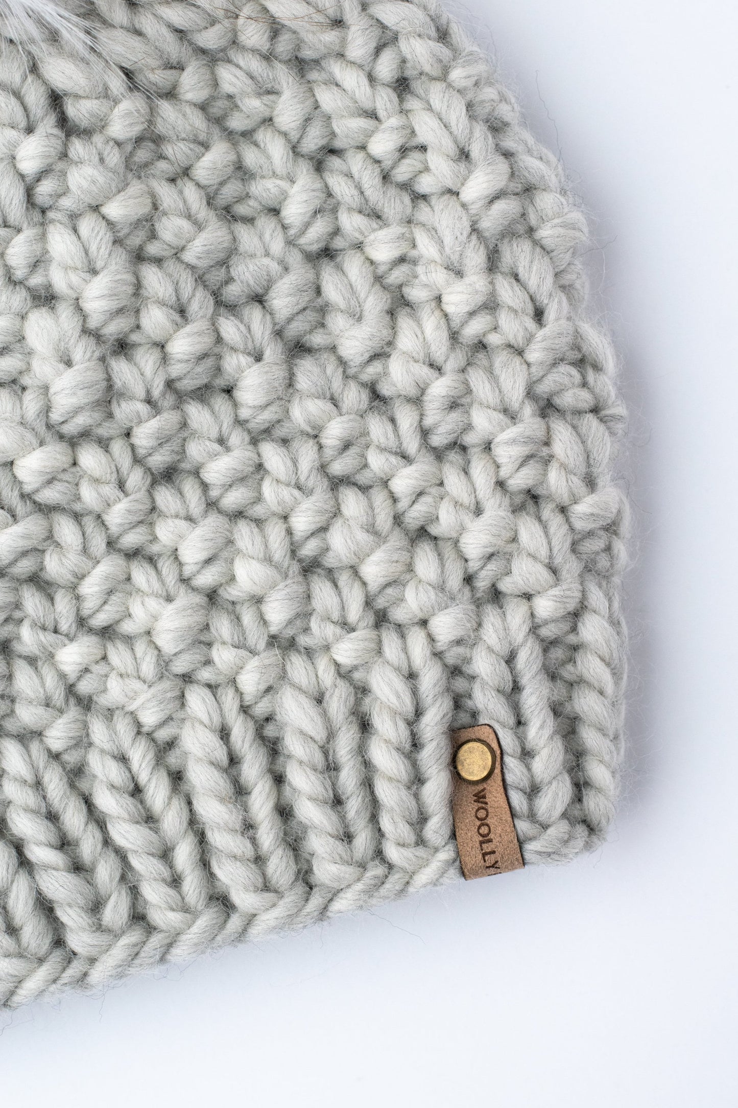 Light gray Peruvian wool knit hat with faux fur pom pom from Woolly Bear Knits, stylish and warm winter accessory.