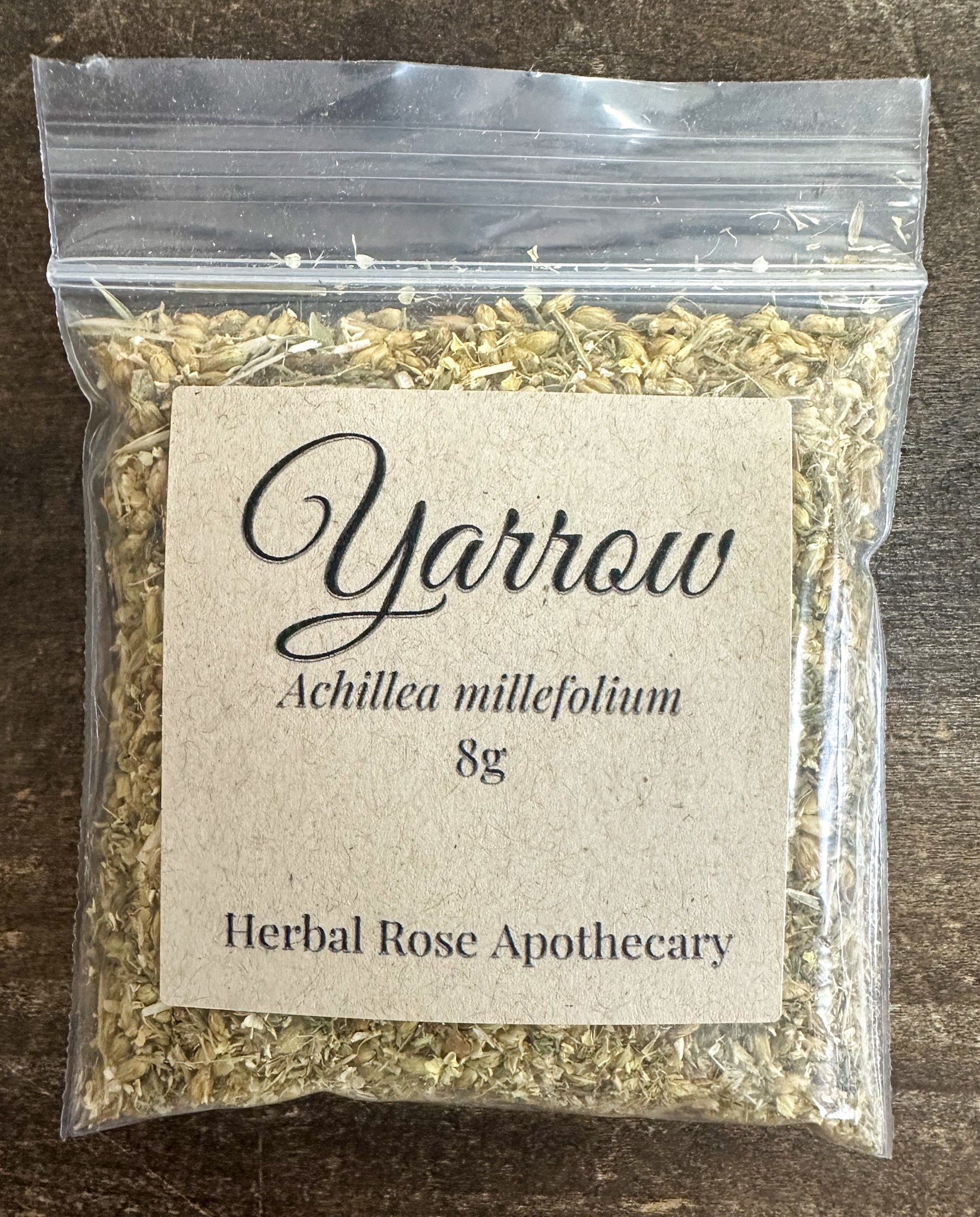 Dried yarrow herb in 8g package from herbalroseapothecary, showcasing finely chopped, aromatic herbal leaves.
