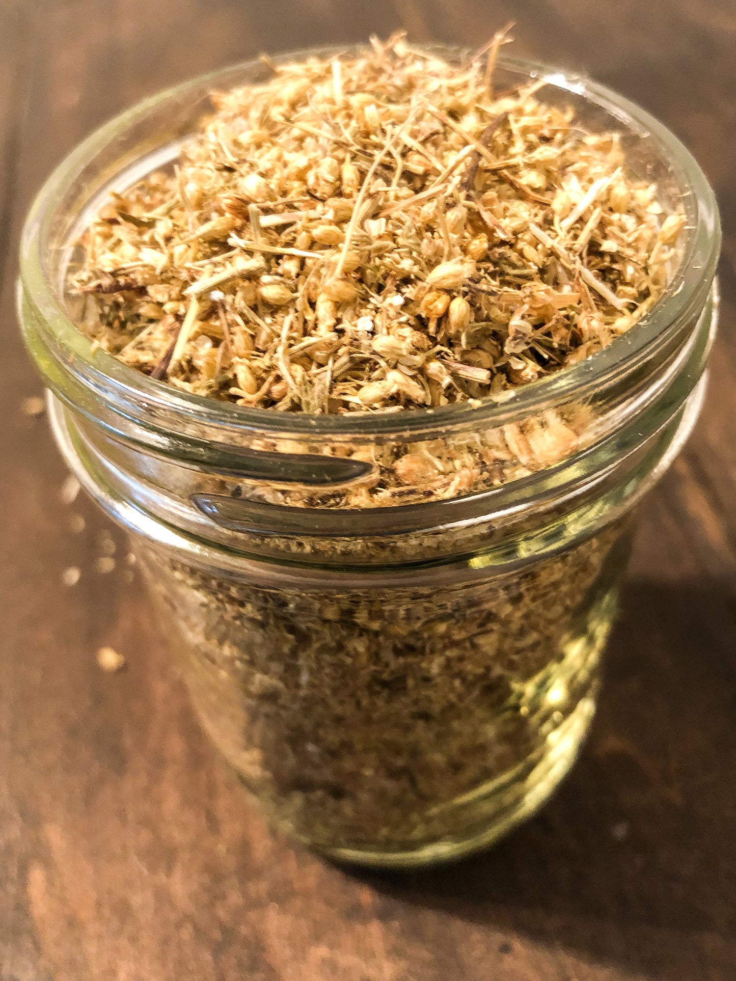Small jar of dried yarrow herbs in a herbalroseapothecary herb jar, showcasing natural dried herbal contents.
