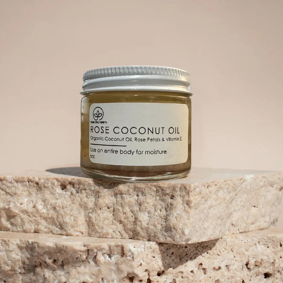 Bottle of Your Only Earth Rose Coconut Oil showing the label and clear liquid inside, used for skin and hair care.