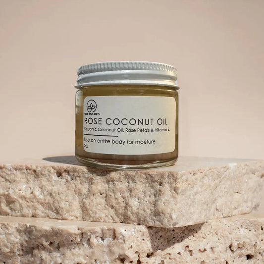 Bottle of Your Only Earth Rose Coconut Oil showing the label and clear liquid inside, used for skin and hair care.