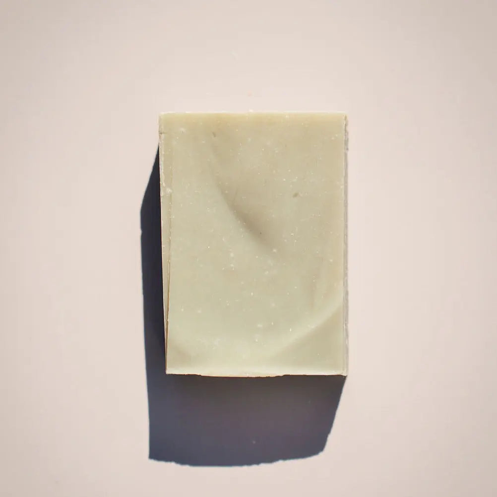 Bar of Meredith's Mint Soap by Your Only Earth with fresh mint leaves and a textured soap surface.