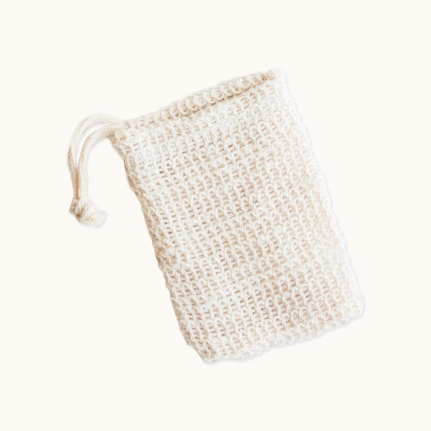 Natural cotton soap saver bag for bath and body use, featuring a drawstring closure and mesh design for gentle exfoliation.