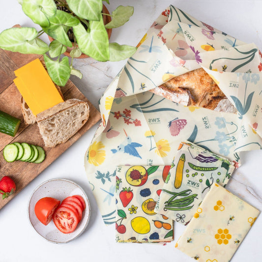 Set of three beeswax food wraps with honeycomb pattern in assorted sizes, natural and plastic-free for food storage.