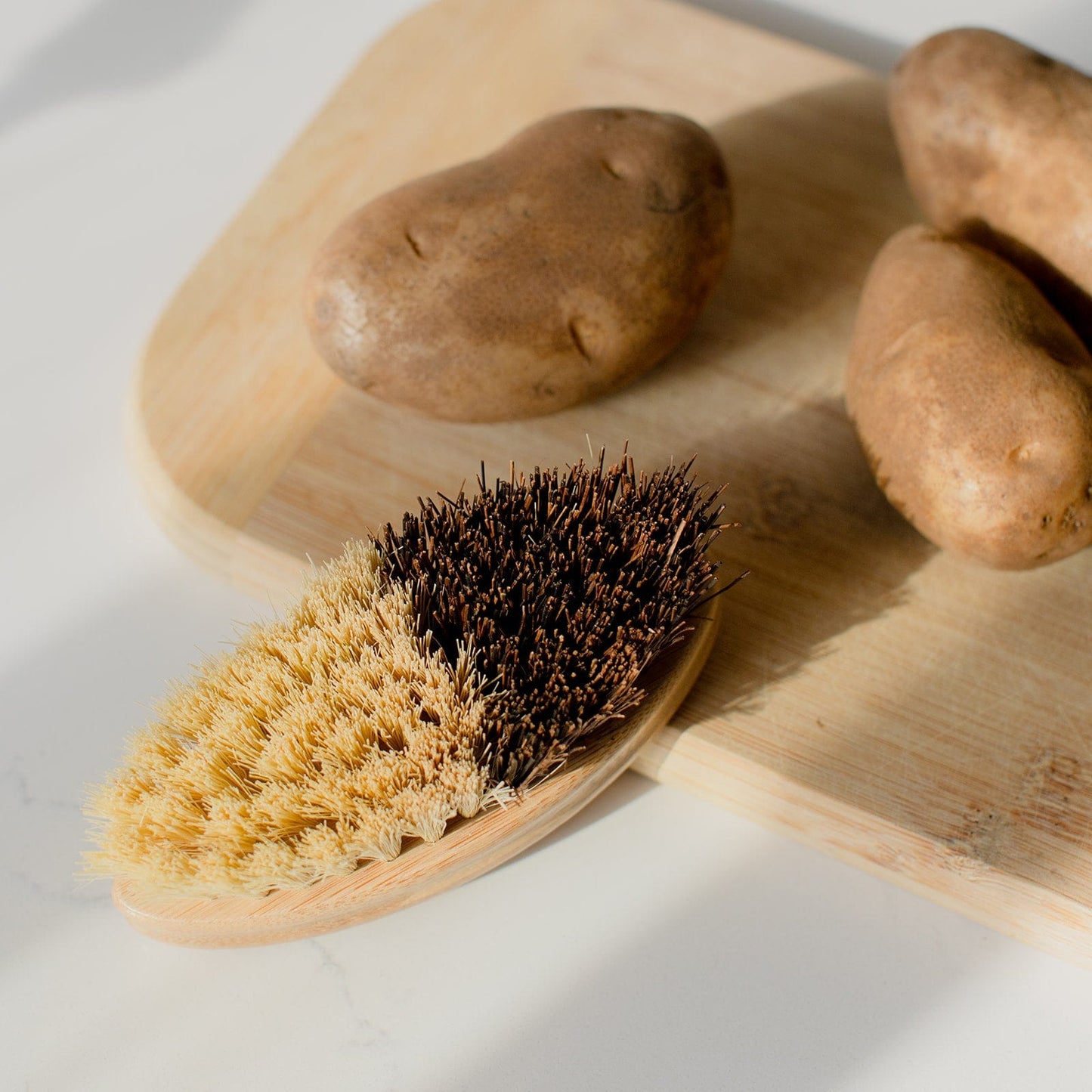 Vegetable scrub brush from ZeroWasteStore.com with wooden handle and bristles for cleaning produce and vegetables.