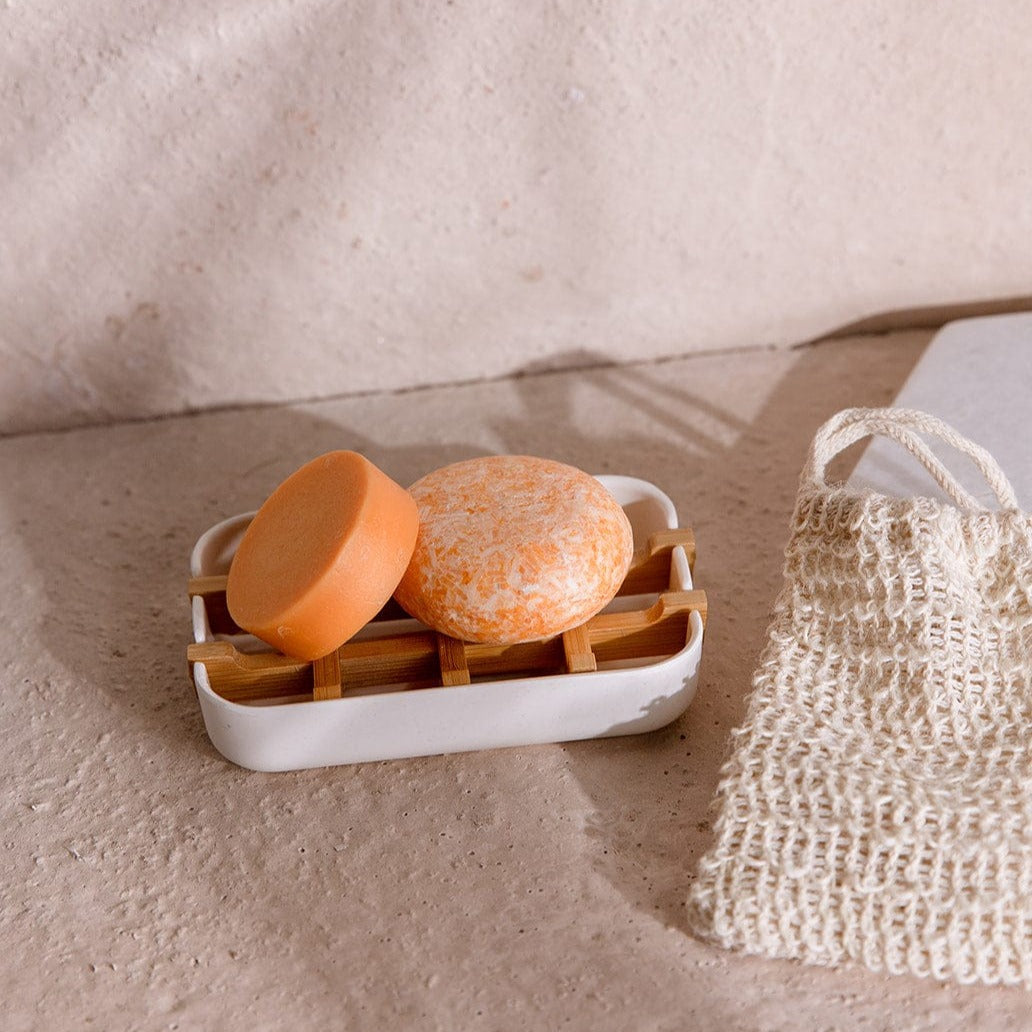 Zero Waste Store mini hair care kit with natural shampoo and conditioner bottles and a white soap dish, eco-friendly hair care set.