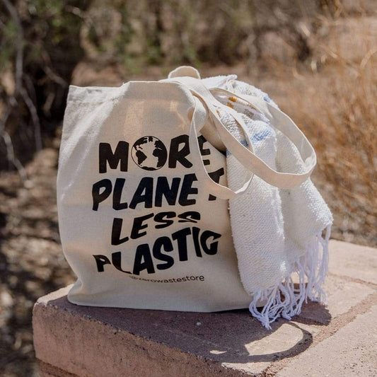 Organic tote bag from ZeroWasteStore.com with "More Planet Less Plastic" print, durable cotton shopping tote for eco-friendly use.