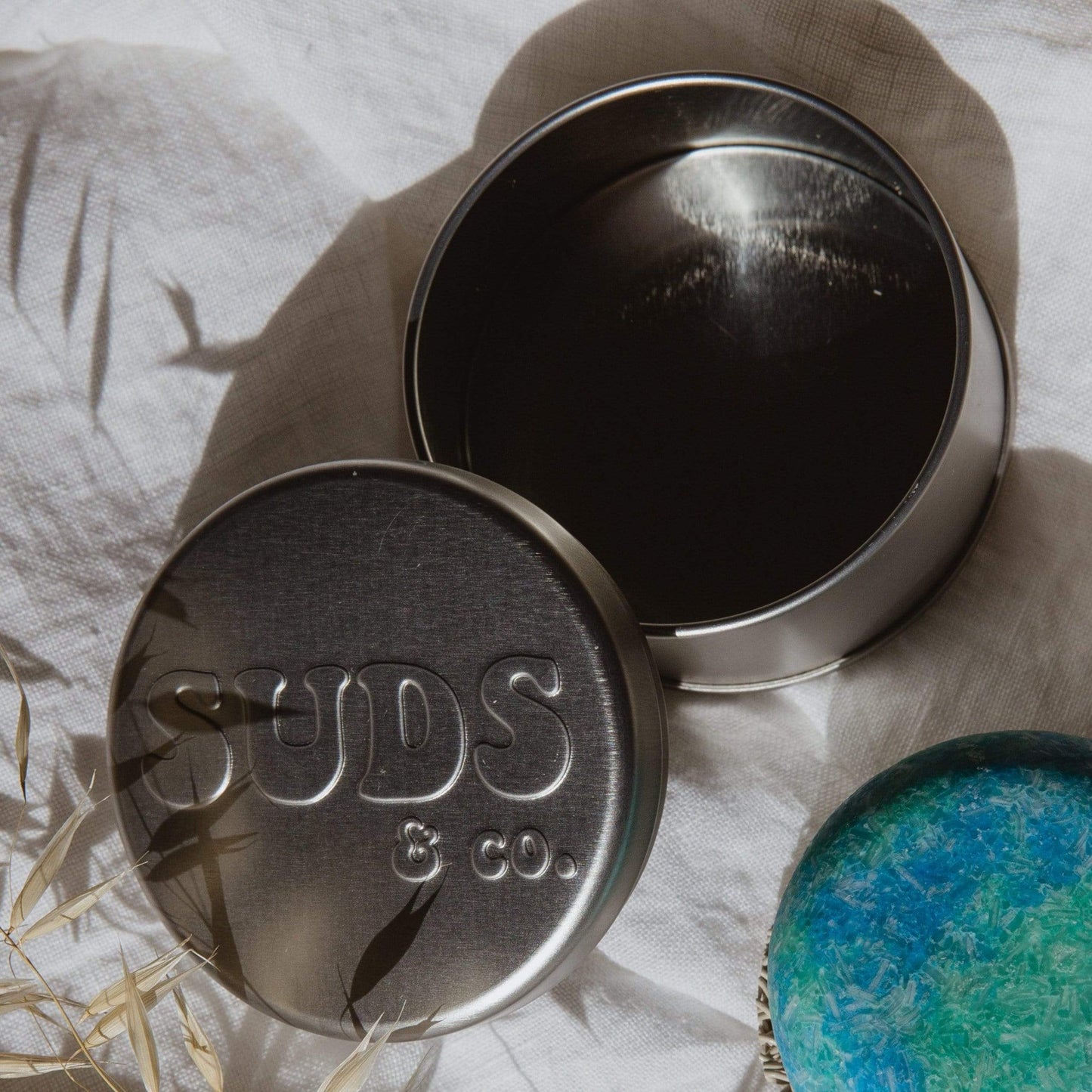 ZeroWasteStore.com Suds & Co. travel tin for shampoo and conditioner storage, compact soap dish and holder in a metal container.