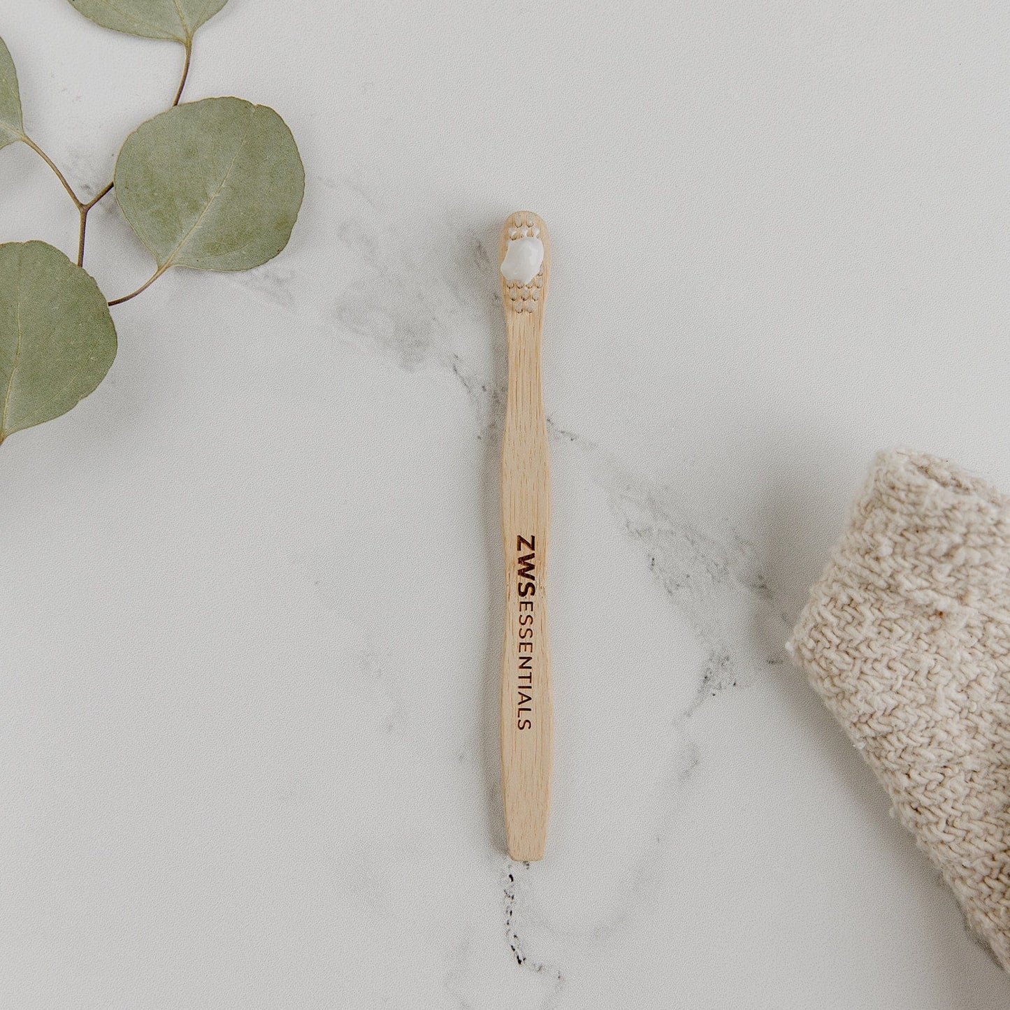 Child-sized bamboo toothbrush from ZeroWasteStore.com with a green handle and soft bristles for gentle oral care.