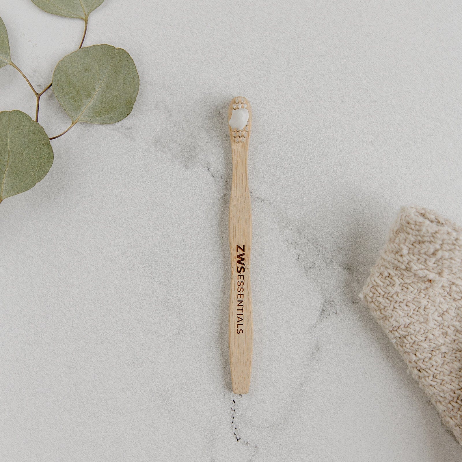 Child-sized bamboo toothbrush from ZeroWasteStore.com with a green handle and soft bristles for gentle oral care.